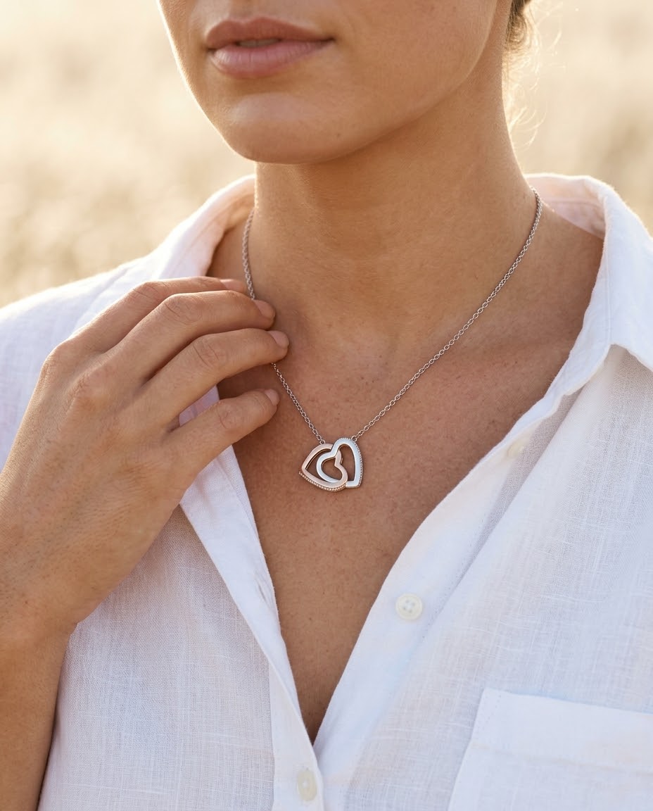 Interlocking Hearts Necklace worn by a woman in a white linen shirt